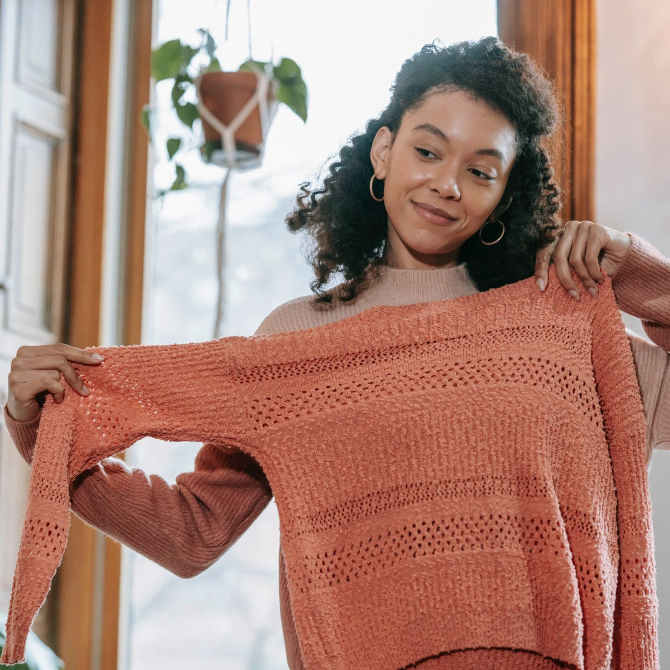 Woman looking at clothes in mirror.
