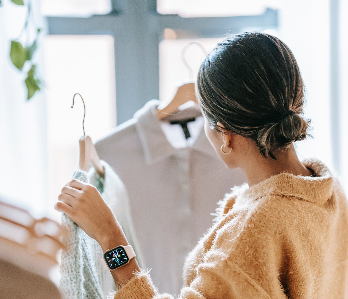 Woman looking at blouses to to try on.